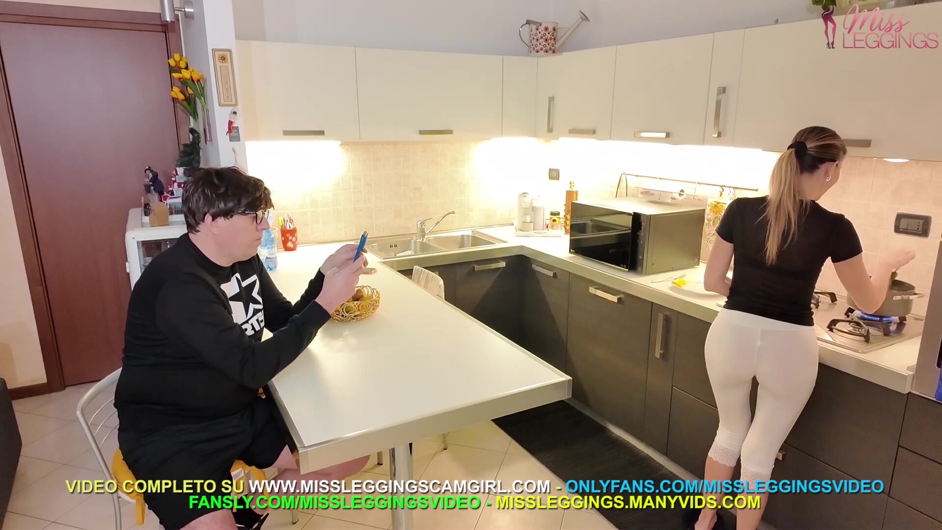 amico figlio scatta foto di nascosto alla mamma in cucina con leggings trasparenti