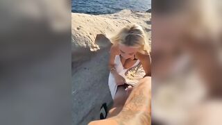 Bionda si mette in ginocchio sugli scogli e succhia il cazzo al ragazzo