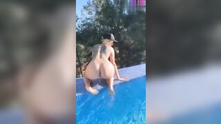 La teen bionda tatuata si mostra nuda in piscina