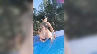 La teen bionda tatuata si mostra nuda in piscina