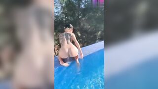 La teen bionda tatuata si mostra nuda in piscina