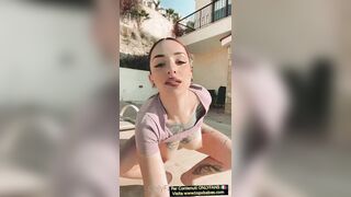 Ragazza dai capelli rossi si spoglia nel giardino della villa