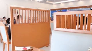 Giovane asiatica fa la pipì seduta al tavolo del ristorante