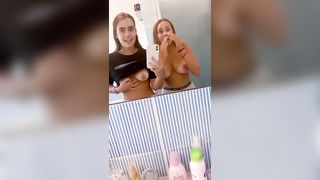 Due amiche fanno le porche davanti allo specchio