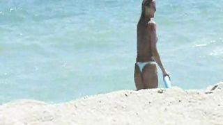 Ragazze nude giocano a frisbee sulla spiaggia