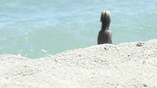 Ragazze nude giocano a frisbee sulla spiaggia