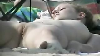 Giovani passere al sole in una spiaggia per nudisti